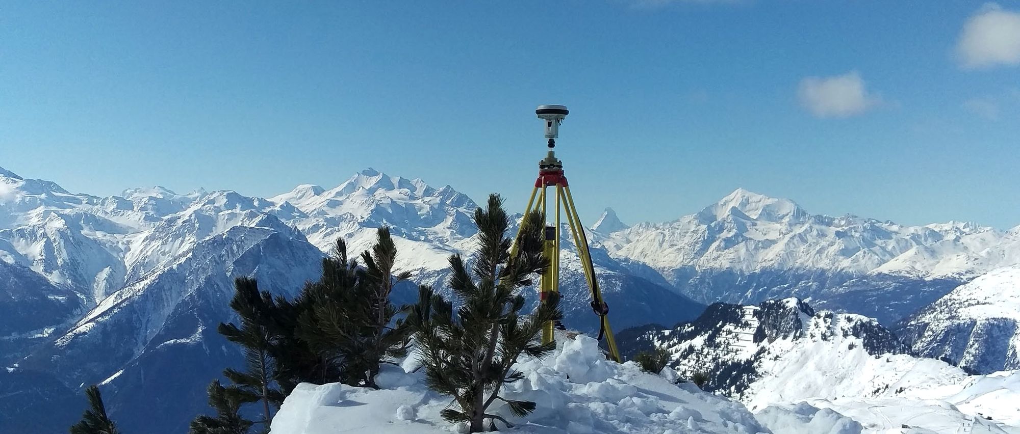 GNSS-Antenne auf Dreibein über verschneiten Walliser Gipfeln